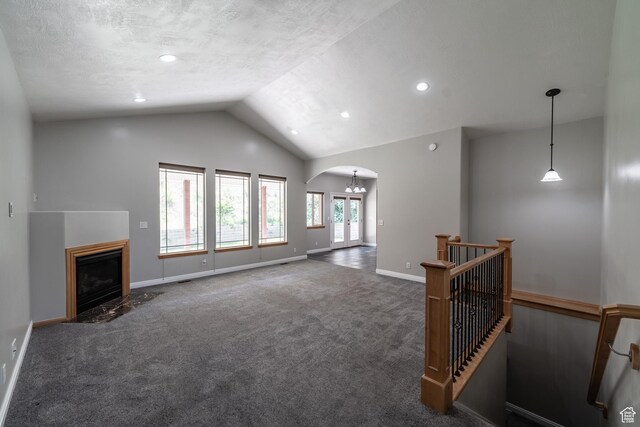 271 E Eagle Ridge Dr, North Salt Lake, UT 84054 - unfurnished living room featuring arched walkways, vaulted ceiling, carpet, a fireplace with flush hearth, and recessed lighting