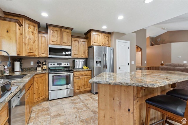 3146 N 750 W, Pleasant View, UT 84414 - kitchen with appliances with stainless steel finishes, a kitchen breakfast bar, light stone counters, recessed lighting, and open floor plan