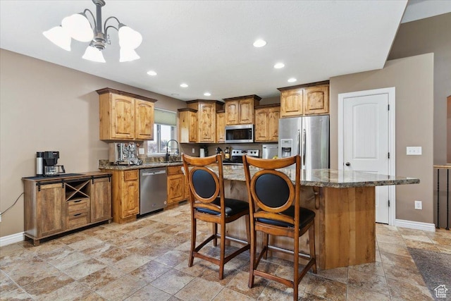 3146 N 750 W, Pleasant View, UT 84414 - kitchen featuring appliances with stainless steel finishes, stone tile flooring, a kitchen island, a breakfast bar area, and recessed lighting