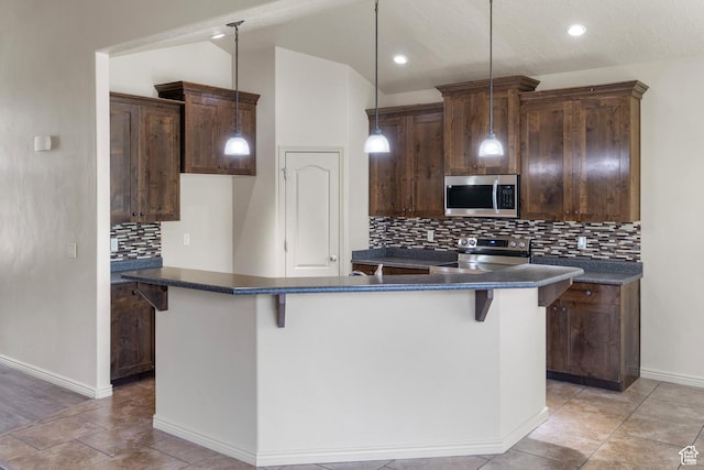 6097 W Cedar Hill Rd S, West Jordan, UT 84081 - kitchen with appliances with stainless steel finishes, dark countertops, a kitchen island, decorative backsplash, and recessed lighting