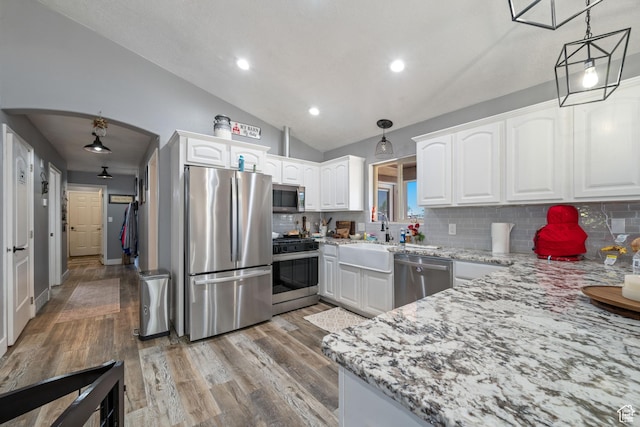 3712 N 250 E, Enoch, UT 84721 - kitchen featuring stainless steel appliances, arched walkways, tasteful backsplash, light stone counters, and vaulted ceiling