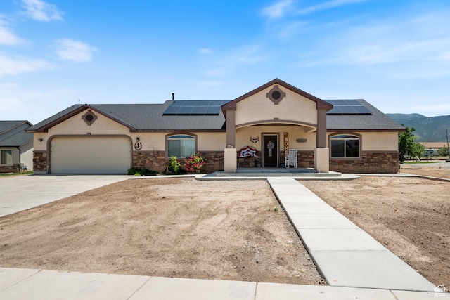 3712 N 250 E, Enoch, UT 84721 - french country style house with stone siding, roof mounted solar panels, stucco siding, and a garage
