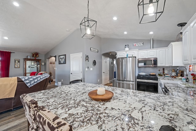 3712 N 250 E, Enoch, UT 84721 - kitchen featuring appliances with stainless steel finishes, wood finished floors, light stone countertops, white cabinetry, and a peninsula