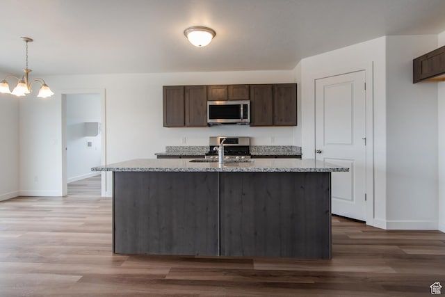 1170 W High Plains Dr Unit 609, Grantsville, UT 84029 - kitchen with stainless steel appliances, light stone countertops, dark brown cabinetry, and light wood-style floors
