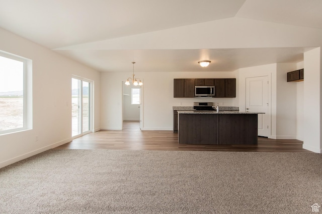 1170 W High Plains Dr Unit 609, Grantsville, UT 84029 - kitchen with stainless steel microwave, a chandelier, dark brown cabinetry, carpet floors, and open floor plan