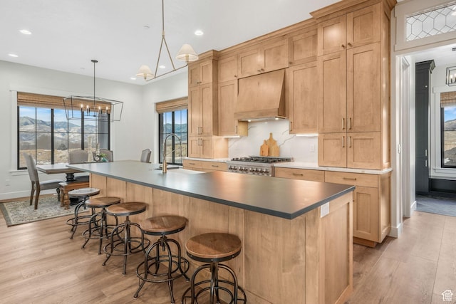 330 N Haystack Mountain Dr, Heber City, UT 84032 - kitchen featuring premium range hood, light wood-style flooring, recessed lighting, a center island with sink, and a kitchen breakfast bar