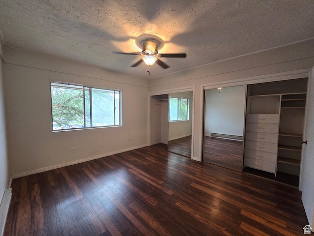 4480 S Atherton Dr Unit 22, Taylorsville, UT 84123 - unfurnished bedroom featuring two closets, a baseboard heating unit, dark wood-style floors, a textured ceiling, and ceiling fan