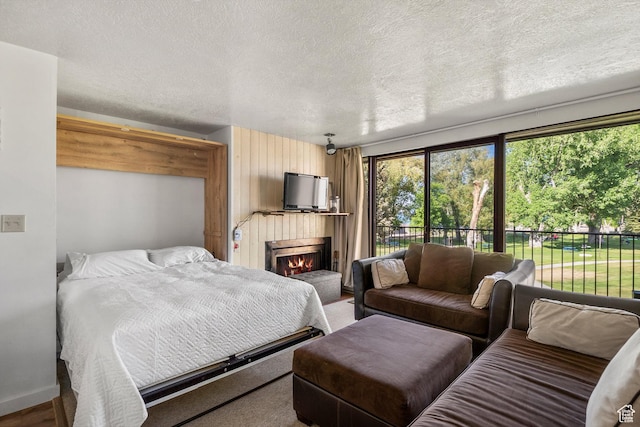 2176 S Bear Blvd # 421, Garden City, UT 84028 - bedroom with access to outside, a lit fireplace, and a textured ceiling