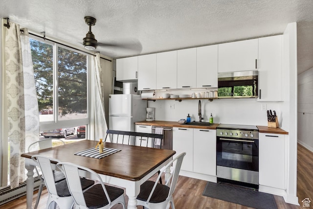 2176 S Bear Blvd # 421, Garden City, UT 84028 - kitchen with butcher block counters, appliances with stainless steel finishes, wood finished floors, white cabinets, and a textured ceiling