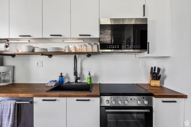 2176 S Bear Blvd # 421, Garden City, UT 84028 - kitchen featuring appliances with stainless steel finishes, butcher block countertops, open shelves, and white cabinets