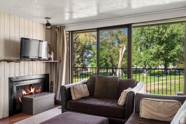 2176 S Bear Blvd # 421, Garden City, UT 84028 - living area with wooden walls, a warm lit fireplace, and a textured ceiling