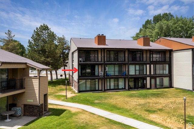 2176 S Bear Blvd # 421, Garden City, UT 84028 - back of house with a chimney, a balcony, and a yard