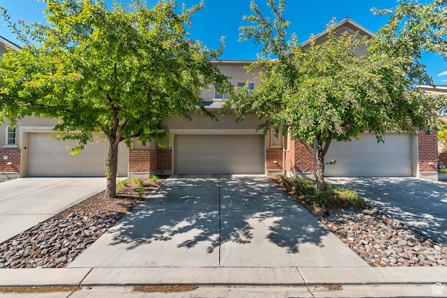 5436 W Brentford Ct, West Valley City, UT 84120 - obstructed view of property featuring brick siding, driveway, a garage, and stucco siding