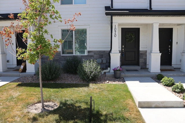 661 W 1920 S Unit 1070, Provo, UT 84601 - doorway to property with stone siding, a lawn, and covered porch