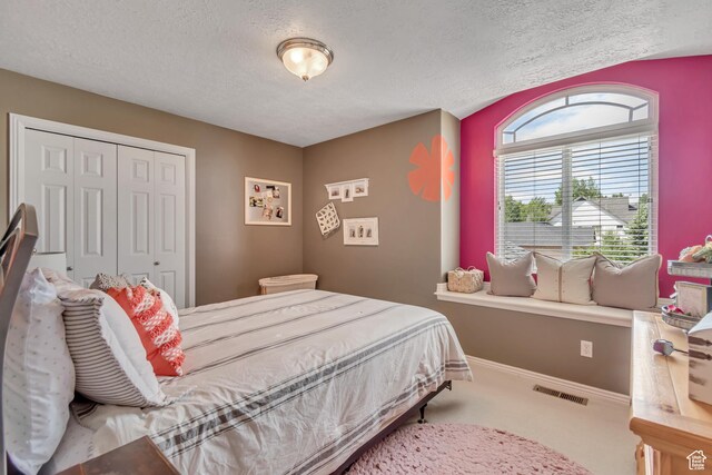 5149 W Rendezvous, Mountain Green, UT 84050 - bedroom with a textured ceiling, a closet, multiple windows, and carpet flooring