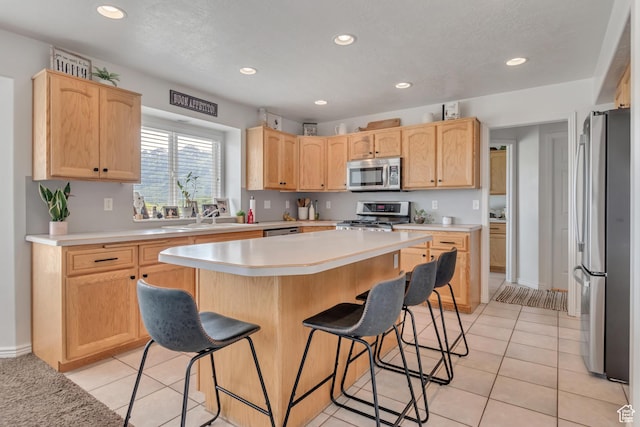5149 W Rendezvous, Mountain Green, UT 84050 - kitchen featuring stainless steel appliances, a breakfast bar, light brown cabinets, recessed lighting, and light countertops