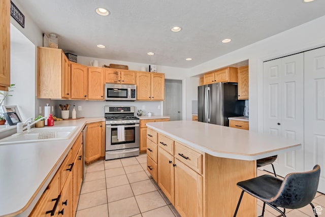 5149 W Rendezvous, Mountain Green, UT 84050 - kitchen with stainless steel appliances, light tile patterned floors, a kitchen island, light countertops, and a breakfast bar area
