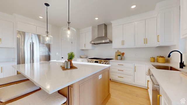 683 N Heritage St, Mapleton, UT 84664 - kitchen with wall chimney range hood, a kitchen island, a breakfast bar area, light wood-style flooring, and recessed lighting
