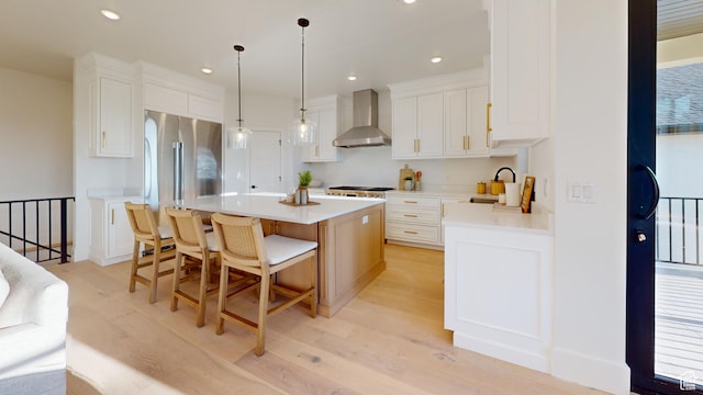 683 N Heritage St, Mapleton, UT 84664 - kitchen featuring wall chimney range hood, light wood-style floors, a center island, high quality fridge, and white cabinets