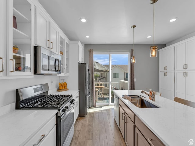 5251 W Linley Ct, Herriman, UT 84096 - kitchen with stainless steel appliances, recessed lighting, light wood finished floors, glass insert cabinets, and white cabinetry