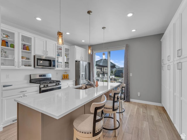 5251 W Linley Ct, Herriman, UT 84096 - kitchen featuring appliances with stainless steel finishes, a kitchen island with sink, a breakfast bar area, white cabinets, and recessed lighting