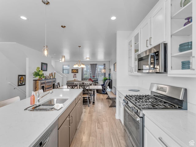 5251 W Linley Ct, Herriman, UT 84096 - kitchen featuring stainless steel appliances, light wood-style flooring, glass insert cabinets, a chandelier, and hanging light fixtures