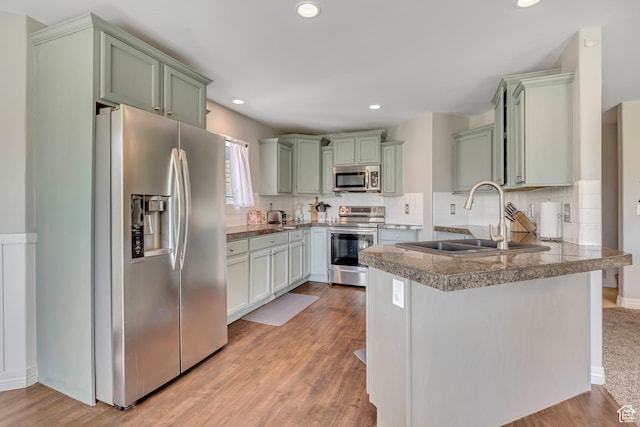 9209 N Prairie Dunes Way, Eagle Mountain, UT 84005 - kitchen featuring appliances with stainless steel finishes, green cabinets, a peninsula, tasteful backsplash, and recessed lighting