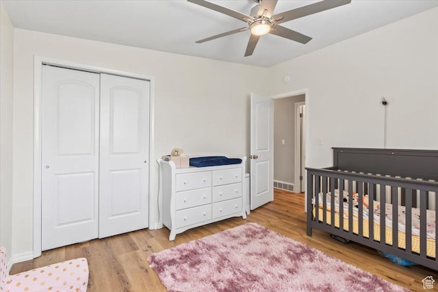 1543 E Spring Run Dr, Salt Lake City, UT 84117 - bedroom featuring wood finished floors, a closet, a nursery area, and ceiling fan
