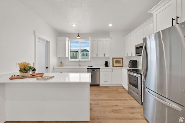 1281 16th St Unit 1281, Ogden, UT 84404 - kitchen with stainless steel appliances, white cabinetry, light countertops, light wood-style floors, and recessed lighting