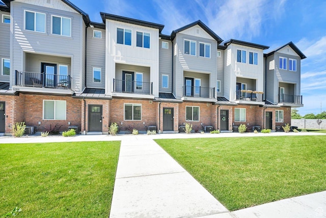 1281 16th St Unit 1281, Ogden, UT 84404 - townhome / multi-family property featuring brick siding, a front yard, and a standing seam roof