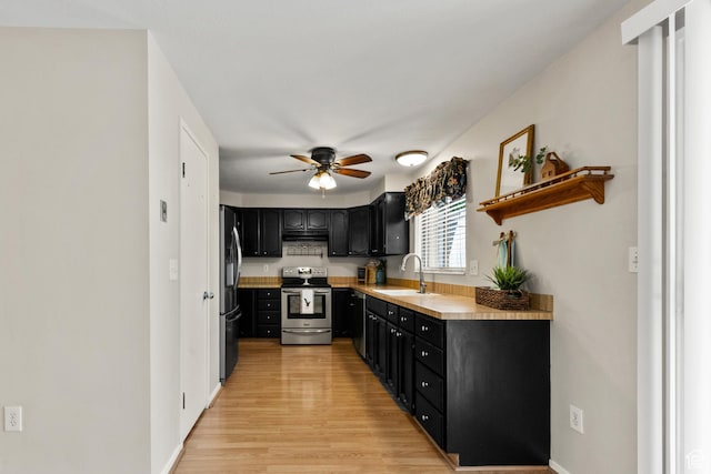2522 E 1950 N, Layton, UT 84040 - kitchen with stainless steel appliances, dark cabinets, ceiling fan, light countertops, and light wood-type flooring
