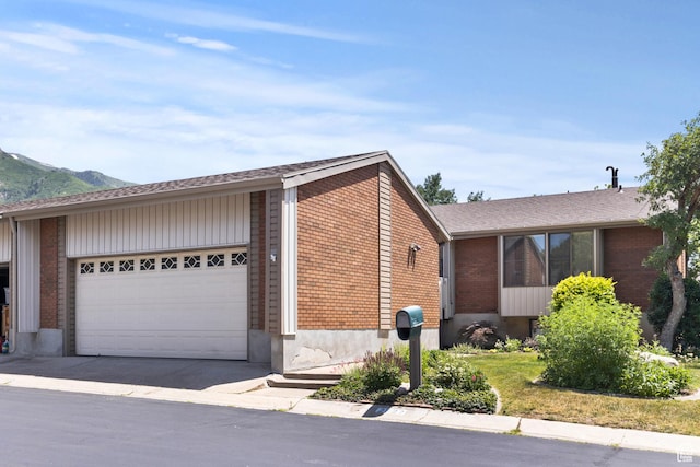 2522 E 1950 N, Layton, UT 84040 - view of home's exterior featuring brick siding, an attached garage, driveway, and a mountain view