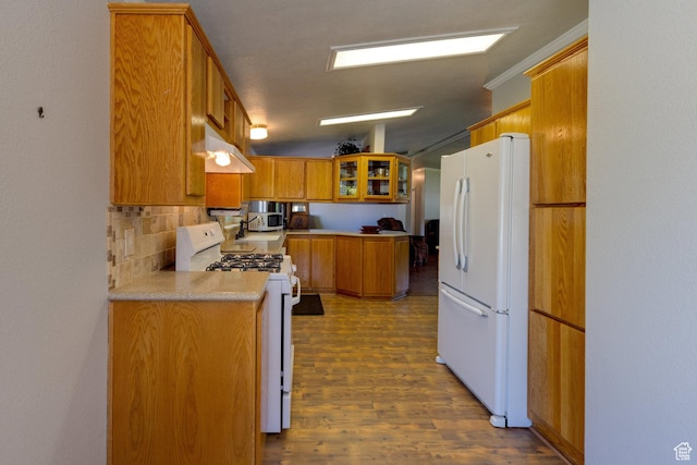 466 W Wingate Ave, Moab, UT 84532 - kitchen featuring white appliances, brown cabinets, decorative backsplash, dark wood finished floors, and light countertops