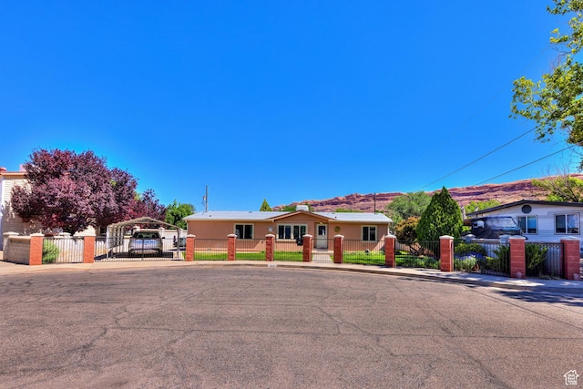 466 W Wingate Ave, Moab, UT 84532 - ranch-style house featuring a detached carport, a gate, a fenced front yard, and driveway