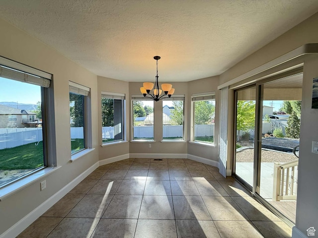 420 N Josephine Ln, Price, UT 84501 - unfurnished sunroom featuring plenty of natural light, a chandelier, tile patterned floors, and a textured ceiling