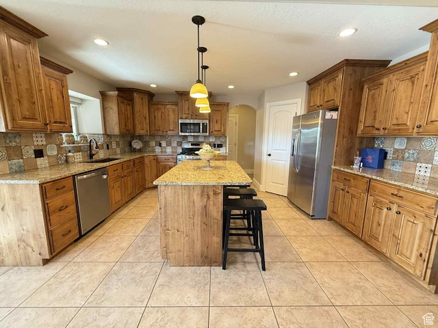420 N Josephine Ln, Price, UT 84501 - kitchen with stainless steel appliances, arched walkways, decorative backsplash, a breakfast bar area, and a center island