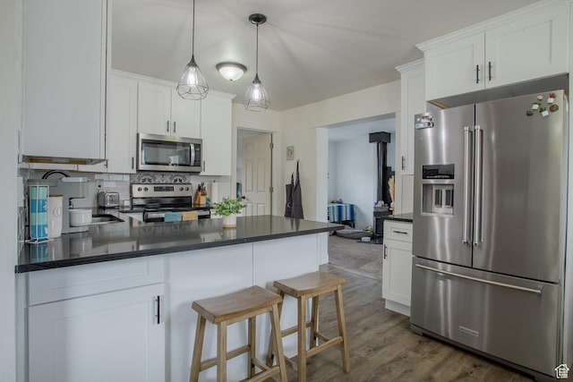 4586 W 4925 S, Kearns, UT 84118 - kitchen featuring stainless steel appliances, white cabinetry, backsplash, a peninsula, and dark wood-style floors