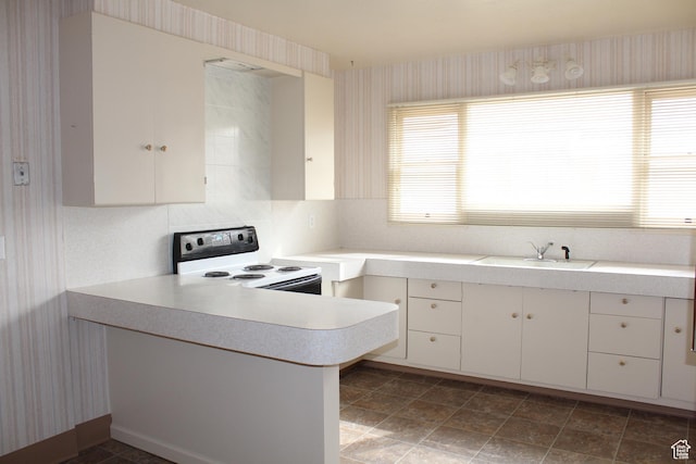 2342 S Van Buren Ave E, Ogden, UT 84403 - kitchen featuring white electric range oven, wallpapered walls, light countertops, a peninsula, and white cabinets