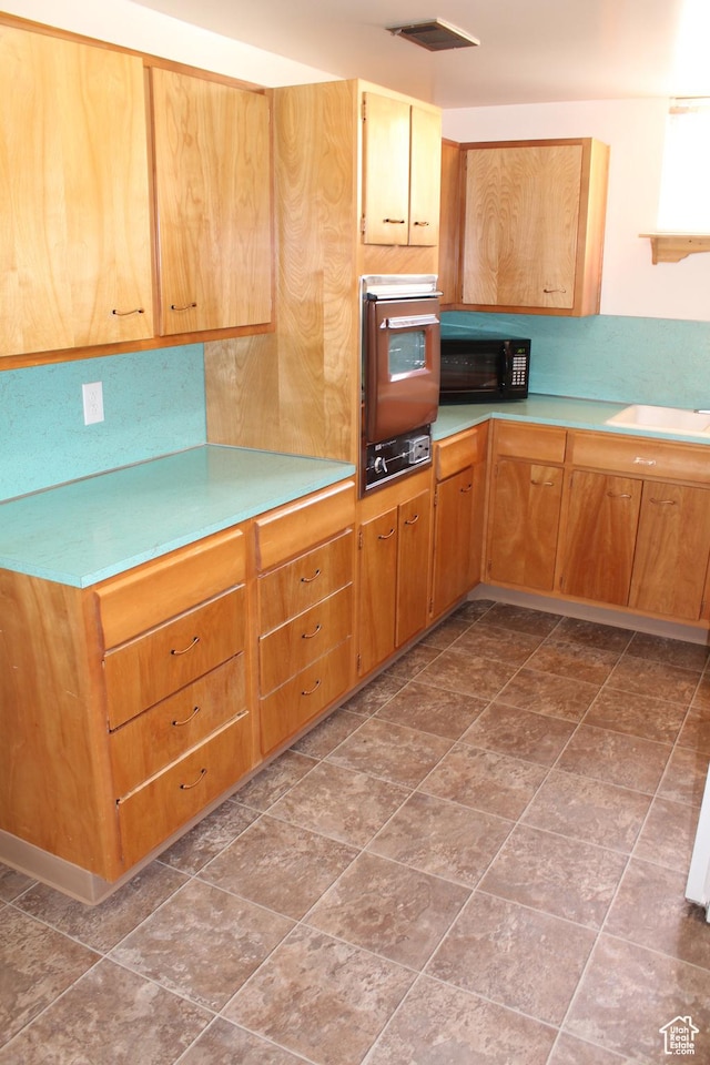 2342 S Van Buren Ave E, Ogden, UT 84403 - kitchen with oven, black microwave, and light countertops