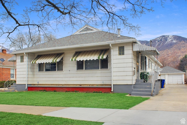 2342 S Van Buren Ave E, Ogden, UT 84403 - bungalow-style home with a mountain view, a garage, a front lawn, and an outbuilding