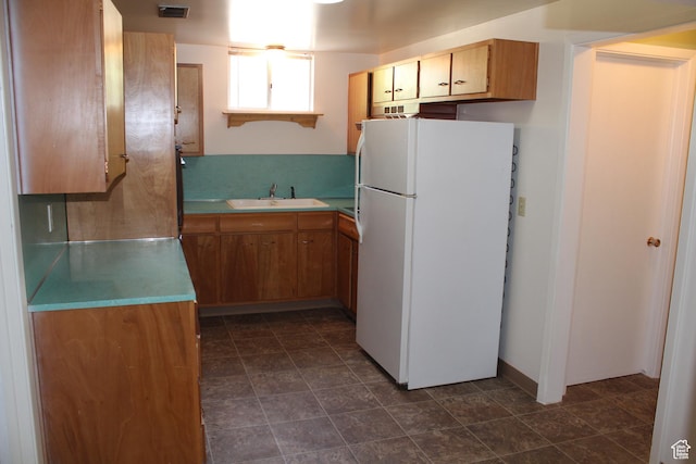 2342 S Van Buren Ave E, Ogden, UT 84403 - kitchen with freestanding refrigerator, light countertops, and brown cabinetry