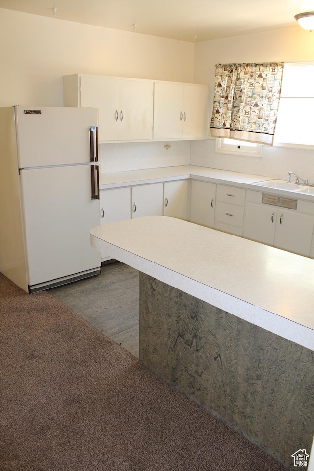 2342 S Van Buren Ave E, Ogden, UT 84403 - kitchen with freestanding refrigerator, white cabinetry, light countertops, and dark wood-type flooring