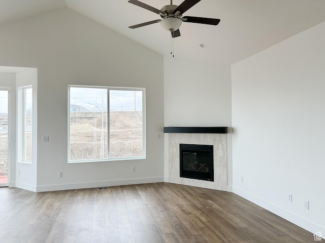 6999 W Hazel Oak Ct, Herriman, UT 84096 - unfurnished living room with wood finished floors, ceiling fan, a glass covered fireplace, and high vaulted ceiling