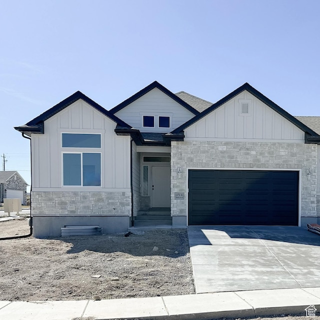 6999 W Hazel Oak Ct, Herriman, UT 84096 - view of front of house featuring stone siding, an attached garage, board and batten siding, driveway, and entry steps