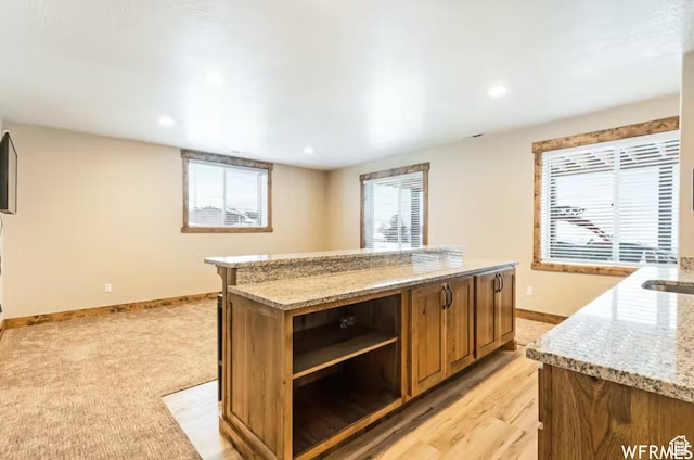 2915 S Golf Course Dr, Garden City, UT 84028 - kitchen featuring light stone countertops, open shelves, a center island, brown cabinets, and recessed lighting