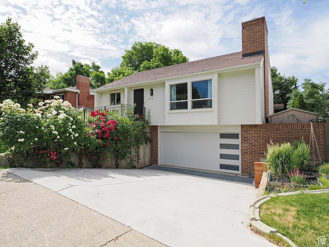 2512 E Redondo Ave S, Salt Lake City, UT 84108 - view of front of property with driveway, brick siding, an attached garage, and a chimney