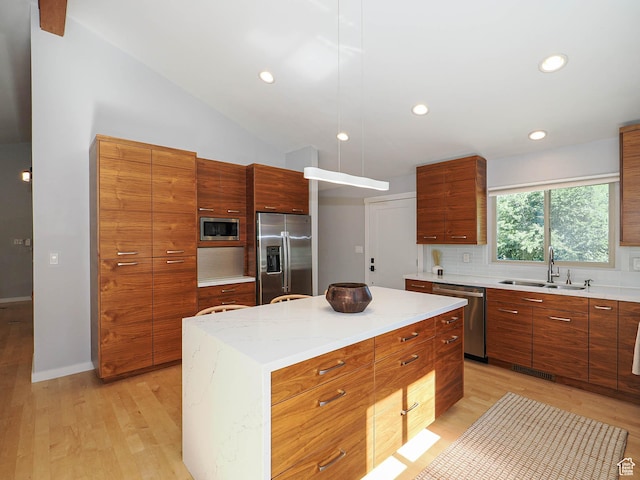 2512 E Redondo Ave S, Salt Lake City, UT 84108 - kitchen featuring appliances with stainless steel finishes, modern cabinets, light wood-type flooring, decorative backsplash, and vaulted ceiling