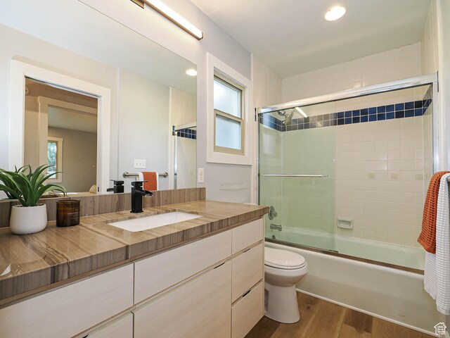 2512 E Redondo Ave S, Salt Lake City, UT 84108 - full bathroom with wood finished floors, vanity, shower / bath combination with glass door, plenty of natural light, and recessed lighting
