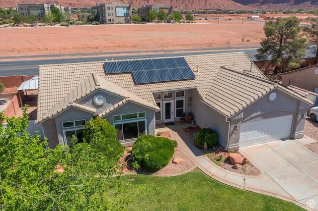329 E 20 S, Ivins, UT 84738 - view of front of home with a tiled roof, a garage, concrete driveway, solar panels, and stucco siding