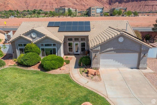 329 E 20 S, Ivins, UT 84738 - view of front of home featuring a tile roof, a garage, solar panels, and concrete driveway